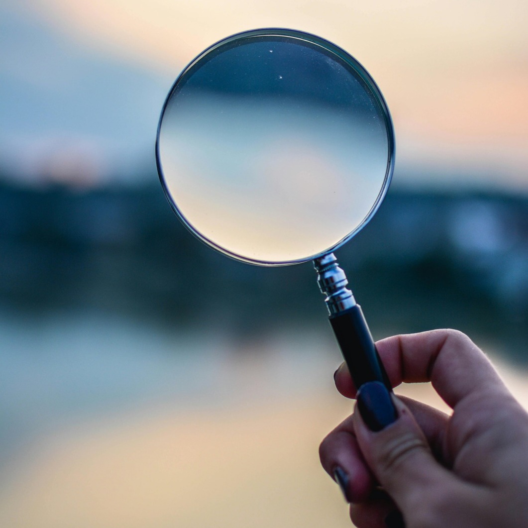 Loupe tenue par une main.